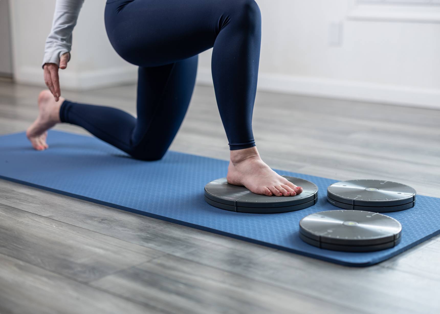 Close up of person with their foot on a rotating disk while in the lunge position